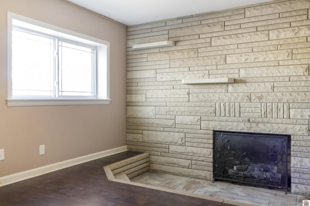 details with hardwood / wood-style floors and a stone fireplace