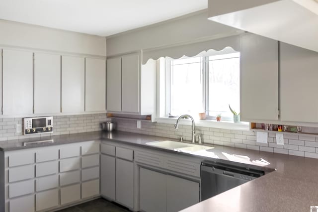 kitchen featuring dishwasher, backsplash, white cabinets, and sink