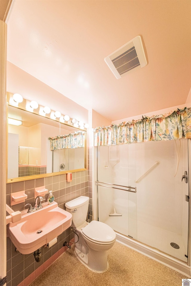 bathroom with a shower, backsplash, sink, toilet, and tile walls