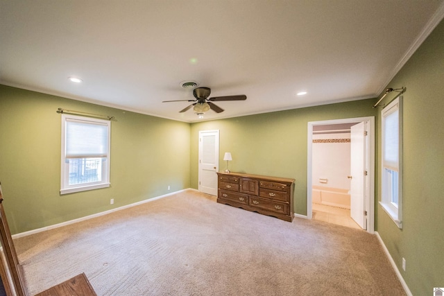 unfurnished bedroom with ceiling fan, light colored carpet, ornamental molding, and connected bathroom