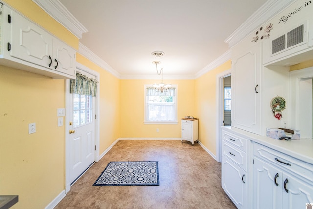 dining area with an inviting chandelier, a wealth of natural light, and ornamental molding