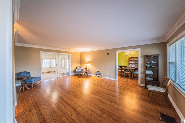 living room with a chandelier, wood-type flooring, and ornamental molding