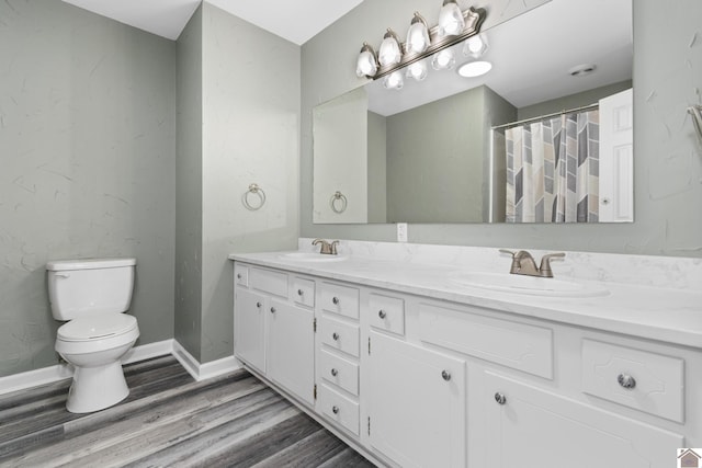 bathroom featuring walk in shower, hardwood / wood-style floors, vanity, and toilet