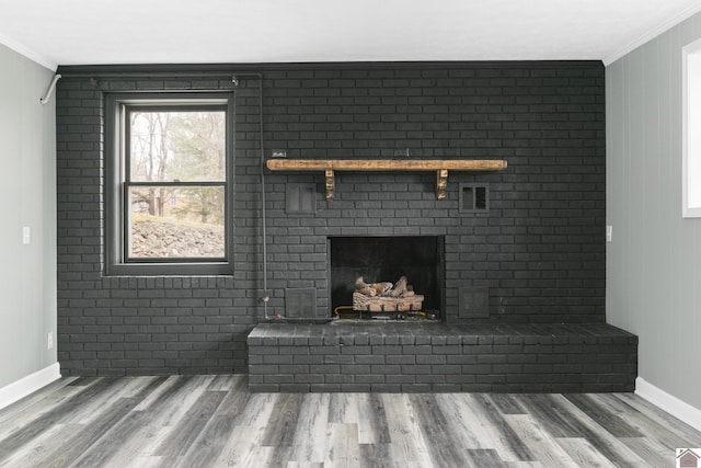 details with hardwood / wood-style floors, ornamental molding, and a brick fireplace