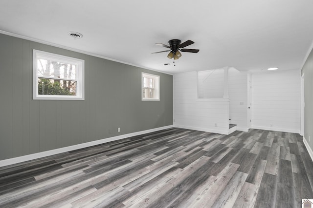 spare room with crown molding, a wealth of natural light, and dark wood-type flooring