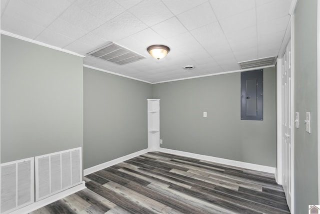 empty room featuring dark hardwood / wood-style flooring, ornamental molding, and electric panel