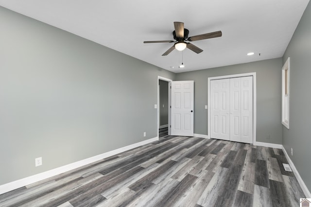 unfurnished bedroom featuring ceiling fan, a closet, and dark hardwood / wood-style floors