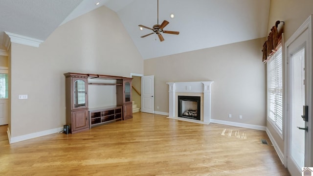 unfurnished living room with ceiling fan, high vaulted ceiling, and light wood-type flooring