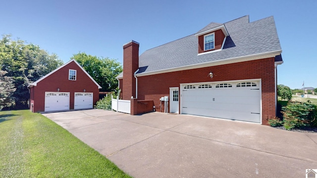 view of side of property with a lawn and a garage