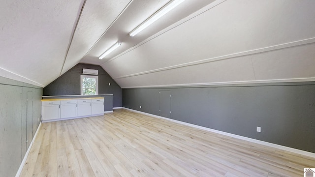 additional living space featuring light hardwood / wood-style floors and lofted ceiling