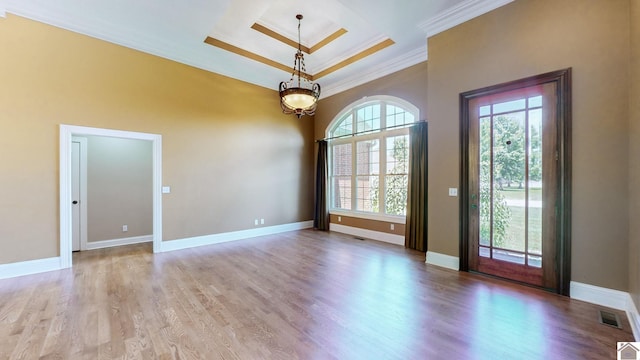 spare room featuring crown molding, a tray ceiling, and light hardwood / wood-style flooring