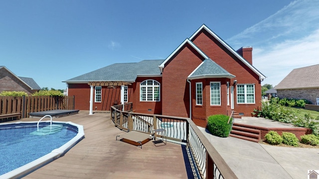 back of house with a swimming pool side deck