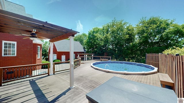 view of pool with a pergola, a deck, and ceiling fan