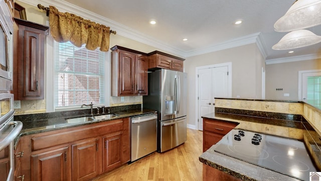 kitchen featuring sink, hanging light fixtures, stainless steel appliances, crown molding, and light wood-type flooring