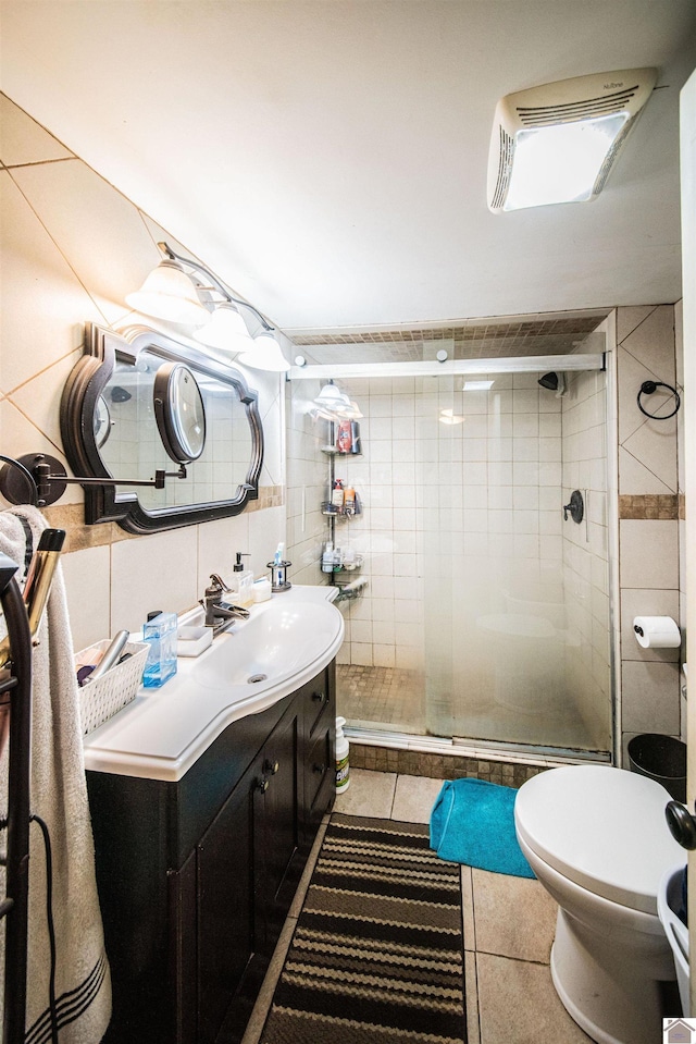 bathroom featuring an enclosed shower, vanity, tile walls, tile patterned flooring, and toilet