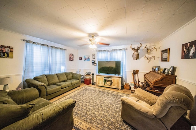 living room with ceiling fan and ornamental molding