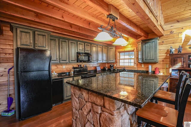 kitchen with wooden walls, a center island, beamed ceiling, and black appliances