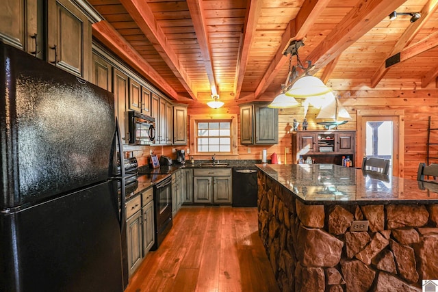 kitchen featuring wood walls, wooden ceiling, black appliances, decorative light fixtures, and beam ceiling