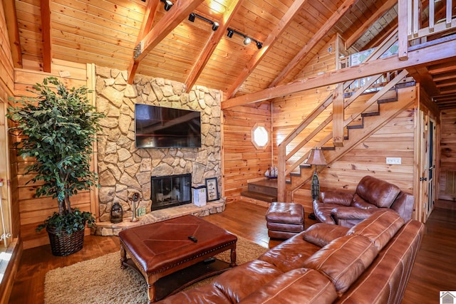 living room with hardwood / wood-style flooring, wood walls, wood ceiling, and a fireplace