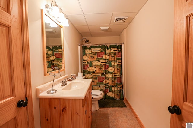 bathroom featuring a paneled ceiling, vanity, curtained shower, and toilet