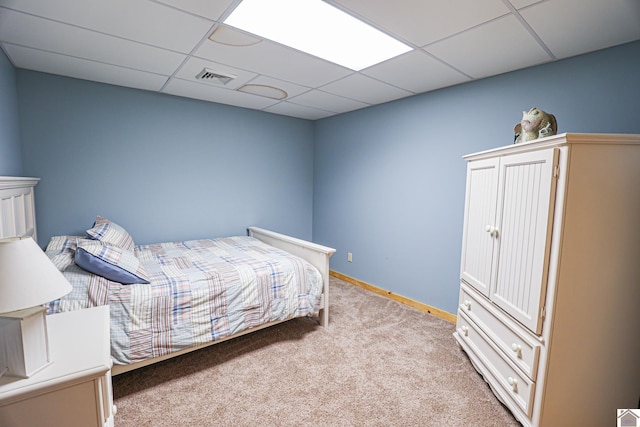 bedroom with a paneled ceiling and light carpet