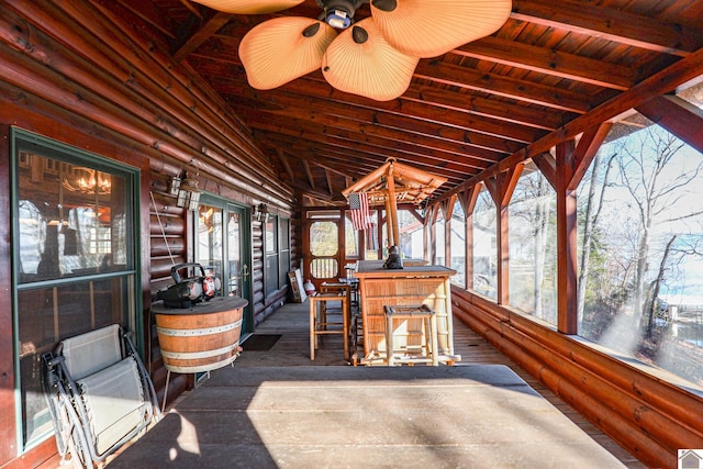 sunroom with vaulted ceiling with beams, ceiling fan, and wood ceiling