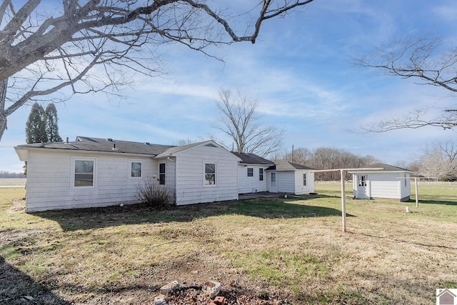 back of property with a yard and a storage unit