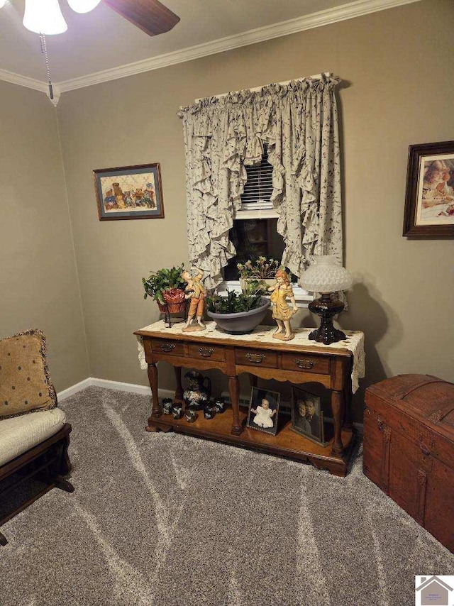 living area with ceiling fan, ornamental molding, and carpet flooring