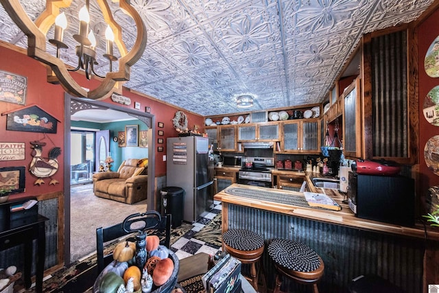 kitchen featuring carpet flooring, sink, stainless steel appliances, and a chandelier