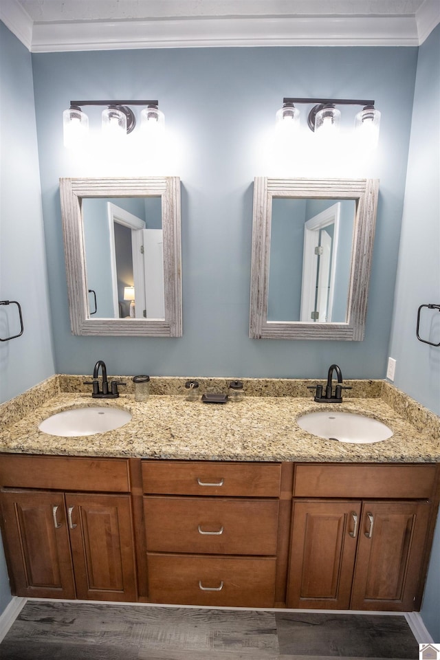 bathroom with crown molding, hardwood / wood-style floors, and vanity