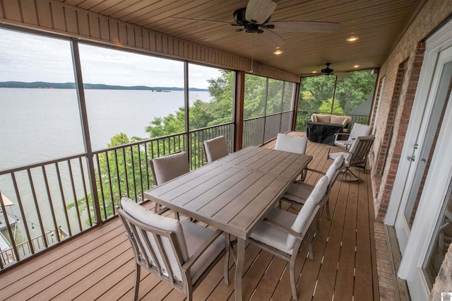 sunroom / solarium featuring ceiling fan, a water view, and wooden ceiling