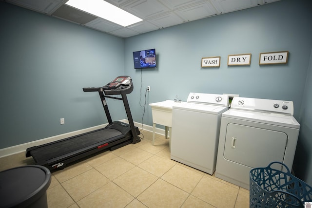 laundry area with light tile patterned floors, sink, and washing machine and clothes dryer