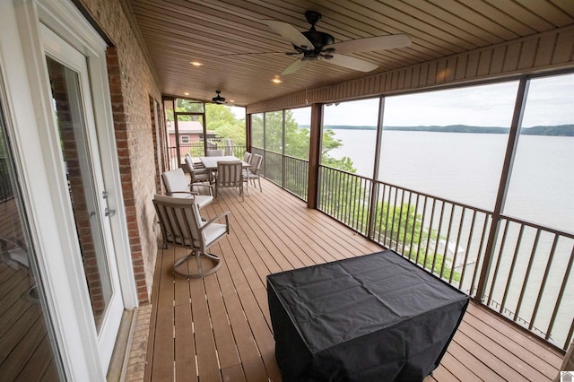 sunroom / solarium with a water view, ceiling fan, and wooden ceiling