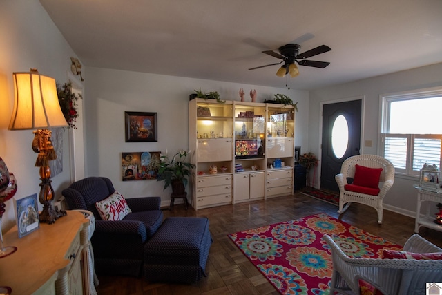 living room featuring dark parquet flooring and ceiling fan