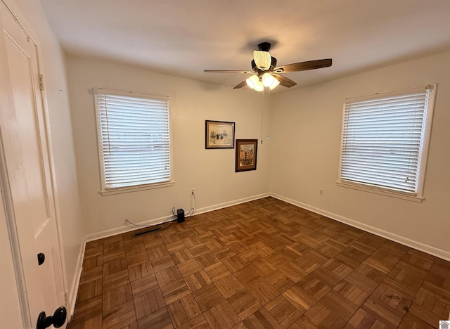 spare room with ceiling fan and dark parquet floors