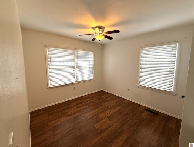 empty room with dark hardwood / wood-style flooring and ceiling fan