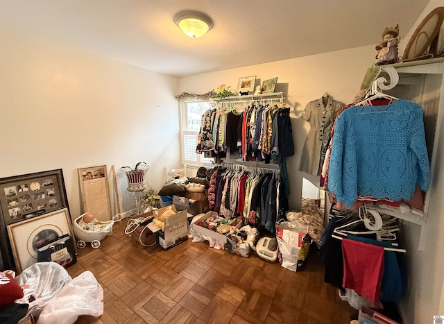 walk in closet with parquet flooring