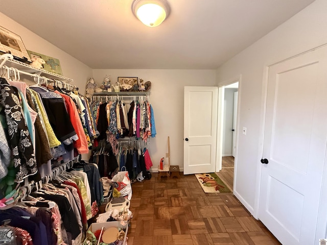 walk in closet with dark parquet floors