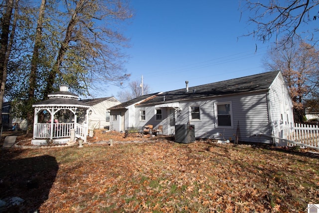 back of property with a gazebo, a yard, and cooling unit