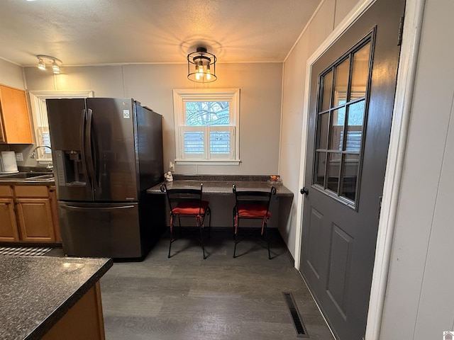 kitchen featuring dark hardwood / wood-style floors, stainless steel fridge, and sink