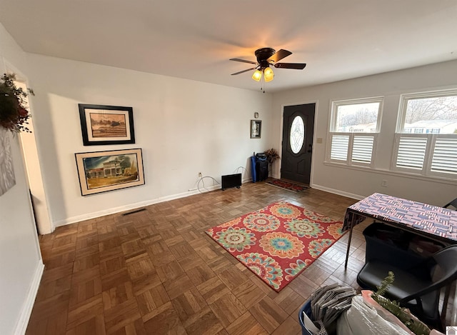 entryway with dark parquet floors and ceiling fan