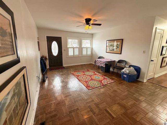 foyer entrance featuring dark parquet floors and ceiling fan