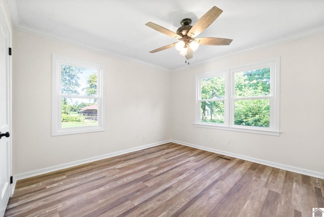 empty room with crown molding, a healthy amount of sunlight, and light hardwood / wood-style floors