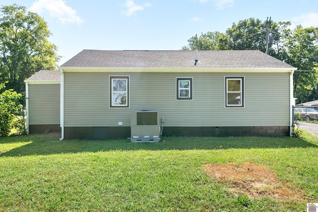 rear view of property featuring a yard and central AC