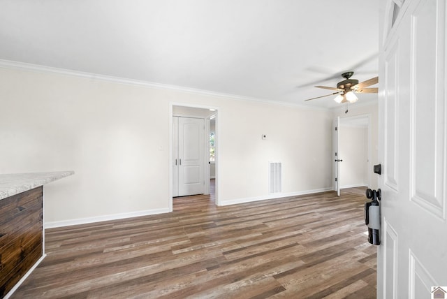 unfurnished living room featuring hardwood / wood-style flooring, ceiling fan, and crown molding