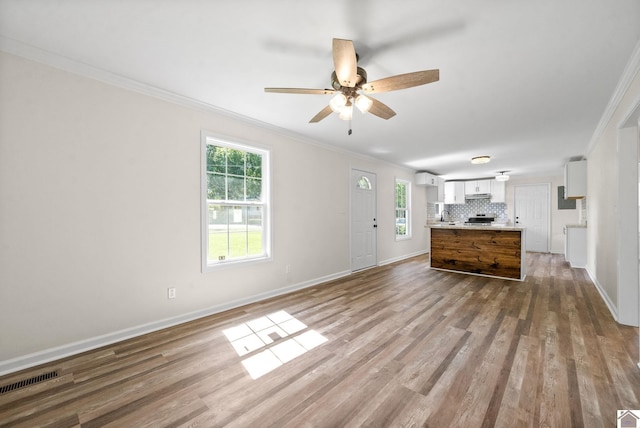 interior space with ornamental molding, hardwood / wood-style flooring, and a healthy amount of sunlight