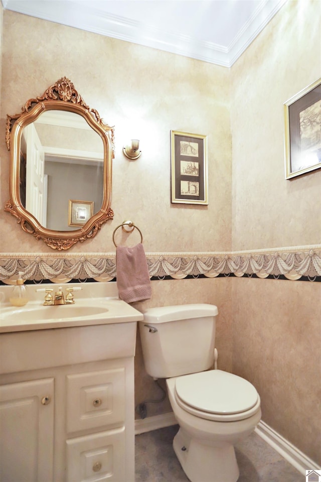 bathroom with toilet, crown molding, and vanity