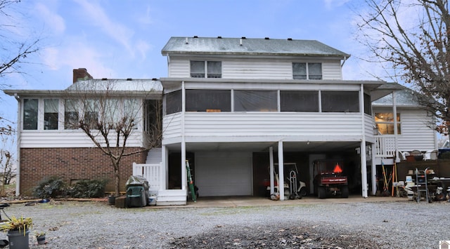 back of property featuring a carport and a sunroom