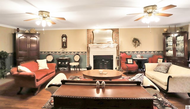 living room featuring wood-type flooring, a brick fireplace, and crown molding