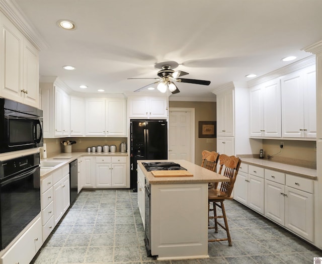 kitchen with white cabinetry, a kitchen bar, a kitchen island, and black appliances